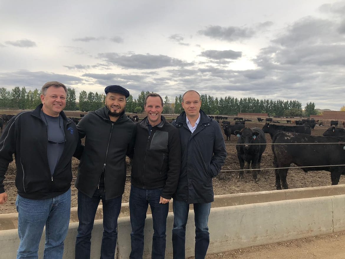 Yerkin Tatishev (center left), Daniel Kunin (center right) and Alex Donov (right) of Kusto Group visit a livestock operation in the United States.