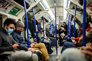 A couple wearing face coverings stare into one another’s eyes as it is mandatory to wear a face covering when travelling on public transport on Friday, Dec. 4, 2020 in London’s West End
