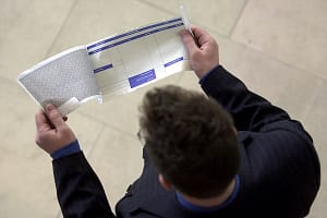 A MAN LOOKS AT HIS PAYSLIP. FOR ROYAL BA