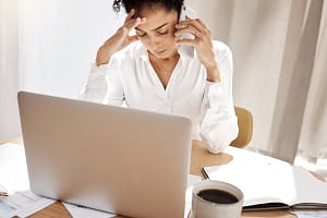 Phone call, stress and black woman frustrated, laptop and reporting theft with bills at desk with laptop. African Americ