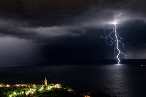 Climbing temperatures and potential thunderstorms Branched lightning and church in front of Rapallo and near Portofino in Liguria,