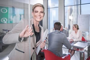 Portrait of businesswoman opening glass door at meeting