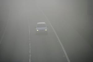 Car in motorway fog, UK.