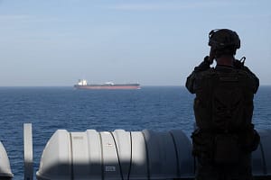 A U.S. Marine aboard the forward-deployed amphibious transport dock ship USS New Orleans (LPD 18) monitors shipping during U.S. maritime blockade operations against Iran in the Strait of Hormuz.