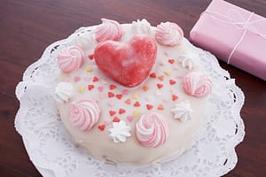 still life of birthday cake decorated with hearts