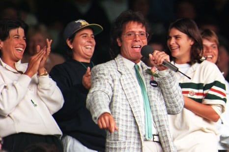 Tennis players (L-R) Gigi Fernandez and Conchita Martinez cheer as Sir Cliff Richard entertains the Centre Court crowd at Wimbledon this afternoon (Wednesday) after rain stopped play