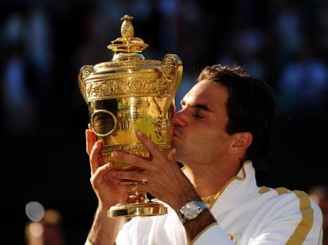 Switzerland's Roger Federer kisses his trophy after winning the Mens Final during the Wimbledon Championships at the All England Lawn Tennis and Croquet Club, Wimbledon, London