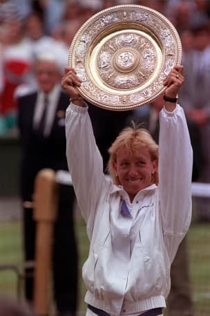 Ladies Singles Champion for a record ninth time Martina Navratilova holds aloft the trophy on the centre court.