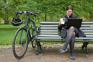 Woman looking at laptop and eating lunch