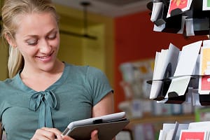 Female sales assistant using digital tablet in stationery shop