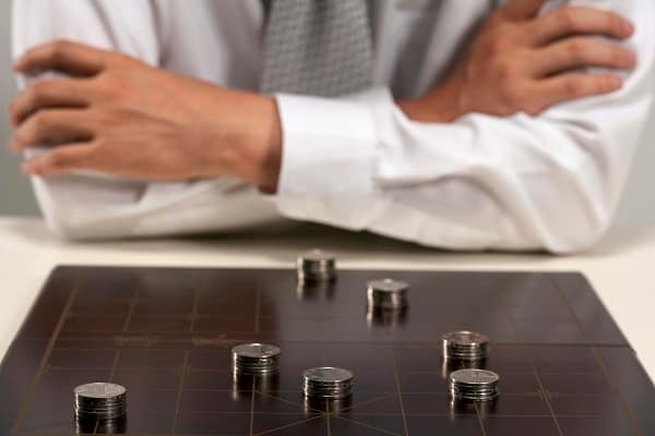 Office woker playing Chinese chess with investment capital