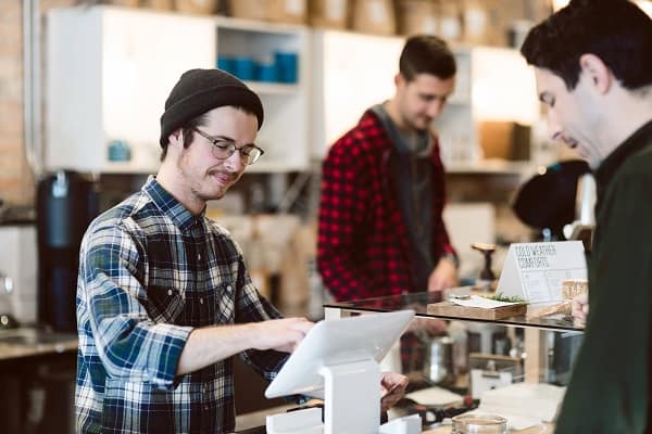 Cashier attending to customer in cafe