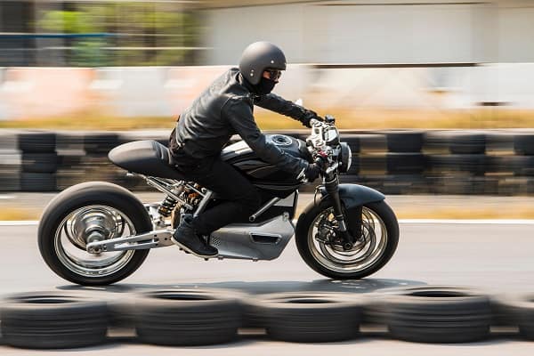 Man testing electric cafe racer motorbike on race track