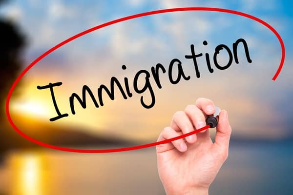Man Hand writing Immigration with black marker on visual screen Man Hand writing Immigration with black marker on visual