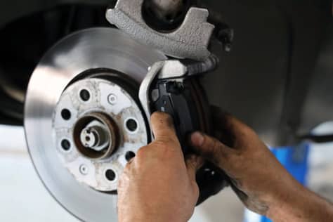 ©AUTODOC Professional brake disc inspection and maintenance showing the precision engineering required for modern braking systems. Proper installation and regular servicing are essential for optimal performance of both traditional and low-emission brake technologies.