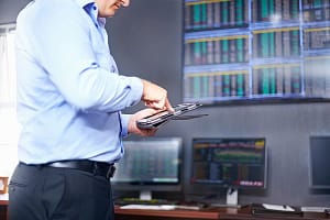 Side view of young mid adult mans mid section in office using digital tablet