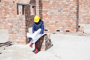 Site manager looking at blueprint on construction site