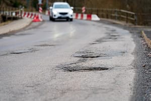 Infrastructure degradation. Poor condition of the road surface. Winter season. Hole in the asphalt, dangerous road Infra