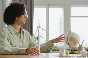 Sustainability woman with globe and wind turbine