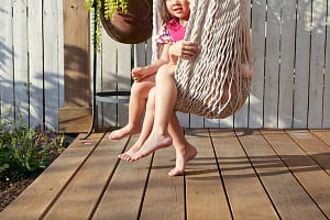 Girls sitting in hammock on porch