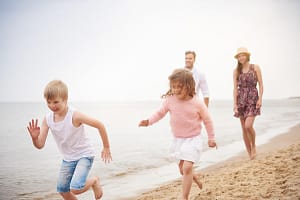 Family running along sandy beach