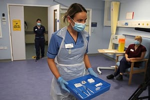 Deputy charge nurse Katie McIntosh arrives to administer the first of two Pfizer