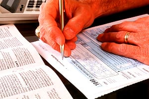 Man filling out income tax forms……….