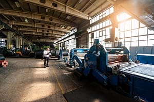 “Man inspecting manufacturing machinery in tyre plant