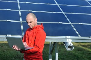 engineer using laptop at solar panels plant field business man engineer using laptop at solar panels plant eco energy fi