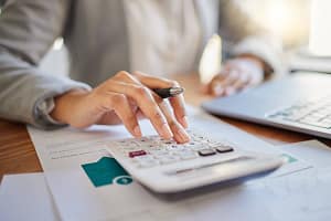 Finance, budget and accounting on a laptop and calculator with financial planner or advisor in an office. Accountant che