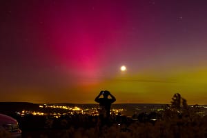 Starke Polarlichter leuchten am Freitagnacht 10.05.2024 über einem Rapsfeld und der Kulisse des Pöhlberg bei Annaberg-Bu