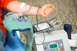 Blood donation hand. Blood bag The hand of a woman who donates blood. Female donor gives blood in a mobile blood donatio