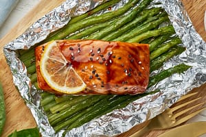 Foil pack dinner with red fish. Fillet of salmon with asparagus. Oven-baked hot dinner, keto paleo diet Foil pack dinner