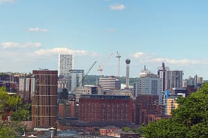 a wide panoramic view showing the whole of leeds city center with towers apartments roads and commercial buildings surro