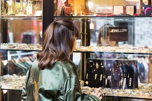 Rear view of young woman looking in jewellery shop window