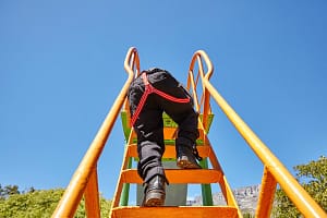 Boy climbing up slide in playground